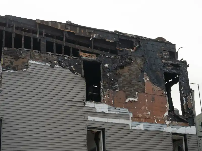 Upper floors of a building severely damaged and charred by fire.