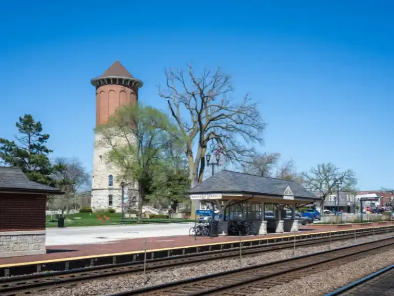 Historic water tower behind a small train station platform labeled Western Springs.